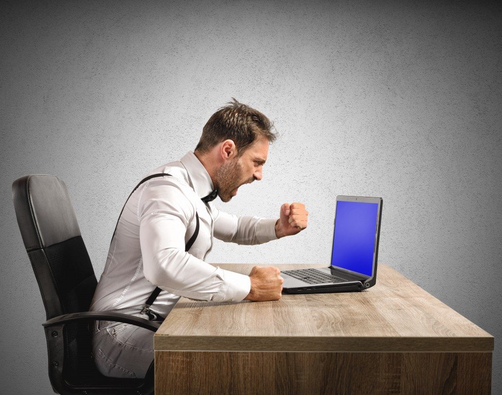 Stressed and angry businessman work at laptop