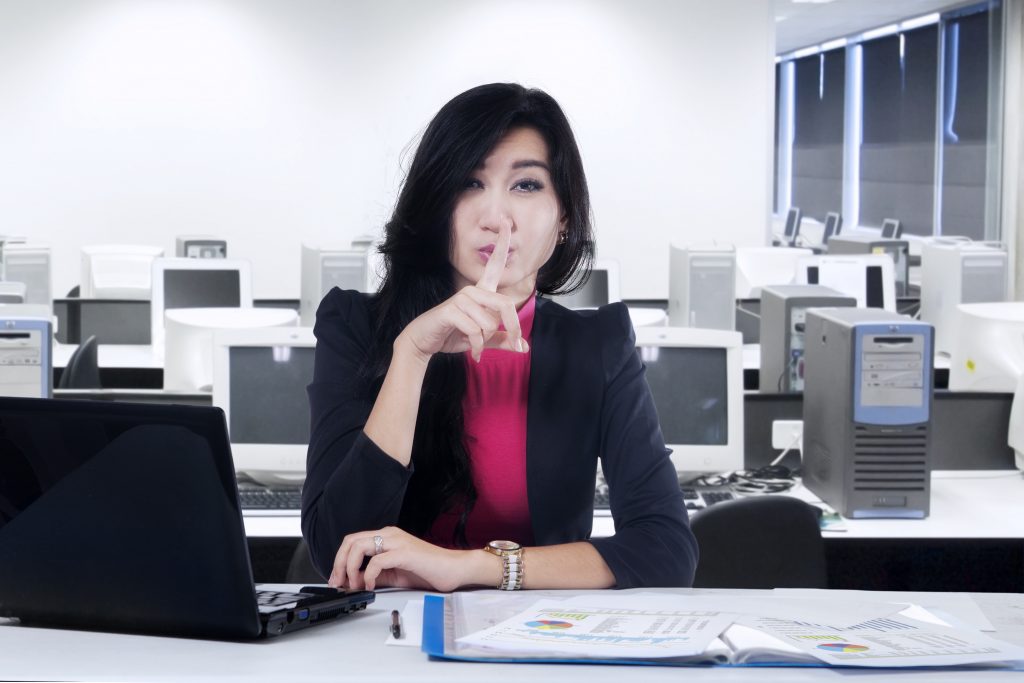 Female entrepreneur working in the office and making silent sign