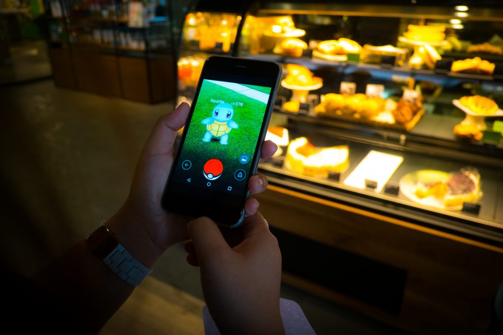 BANGKOK, THAILAND – August 12,2016: Pokemon Go gameplay screenshot on the phone. Pokemon Go is a location-based augmented reality mobile game,Playing in cafe