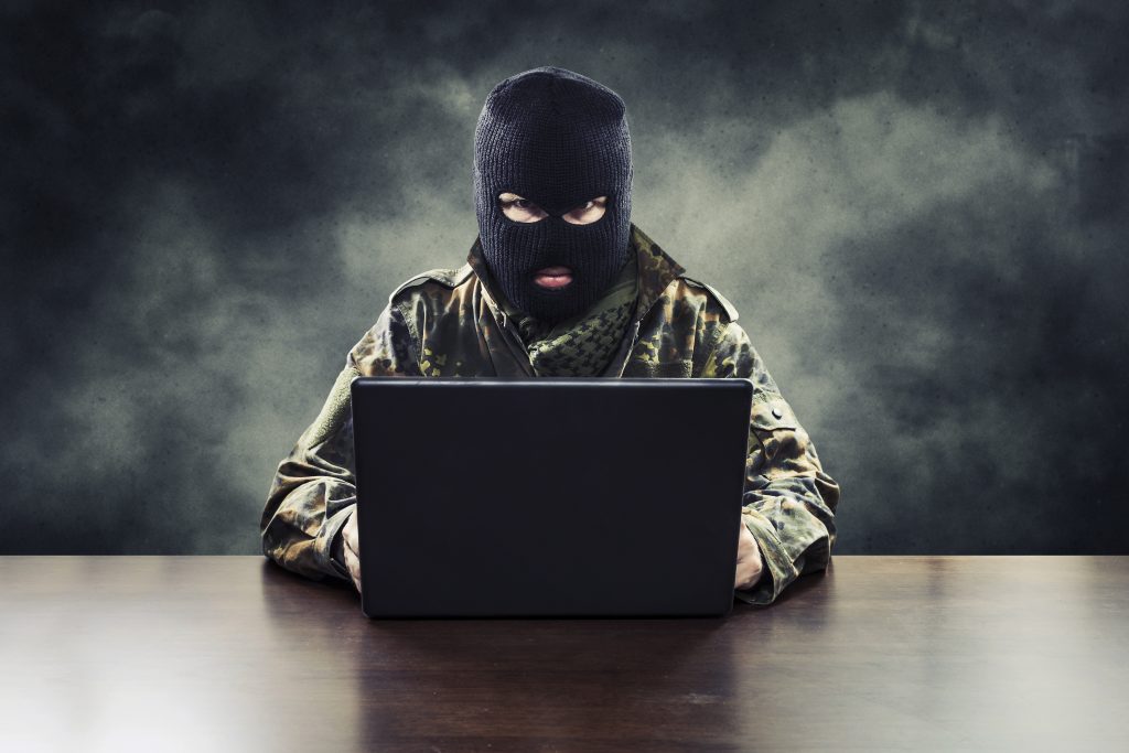 Masked cyber terrorist in military uniform hacking army intelligence
