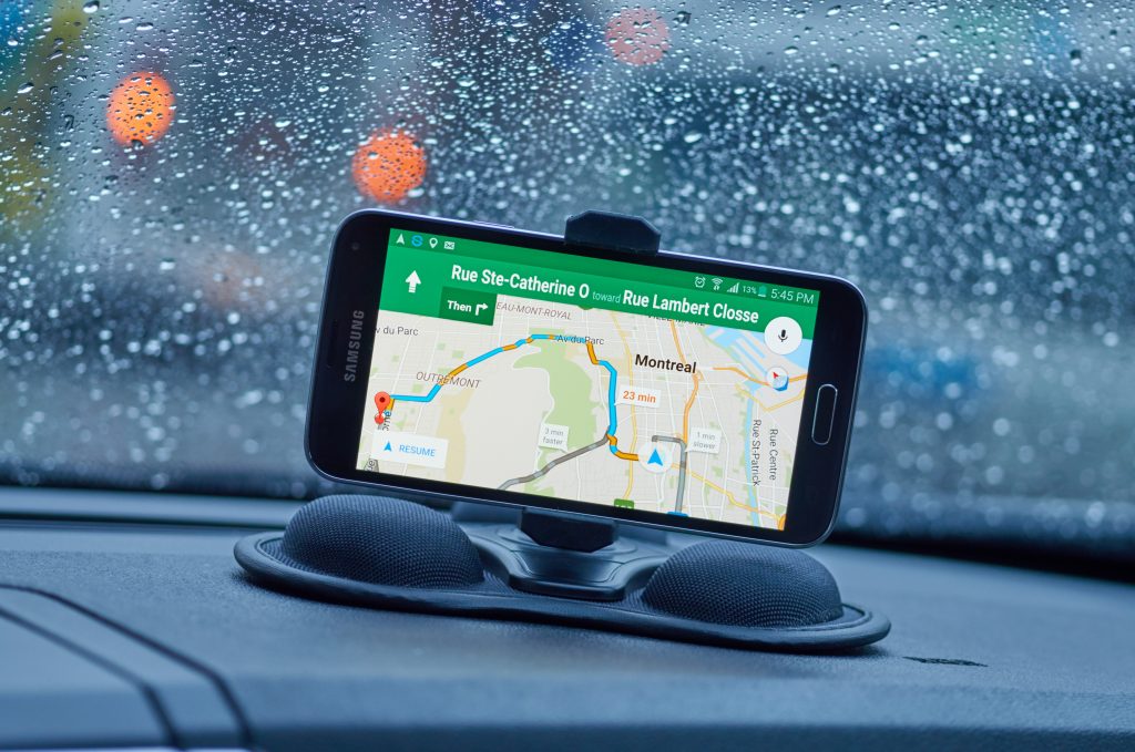 MONTREAL, CANADA - MARCH 15, 2016 - GPS application Google Maps on Samsung S5 im a car over wet windows background. Google Maps is one of the most popular GPS applications.