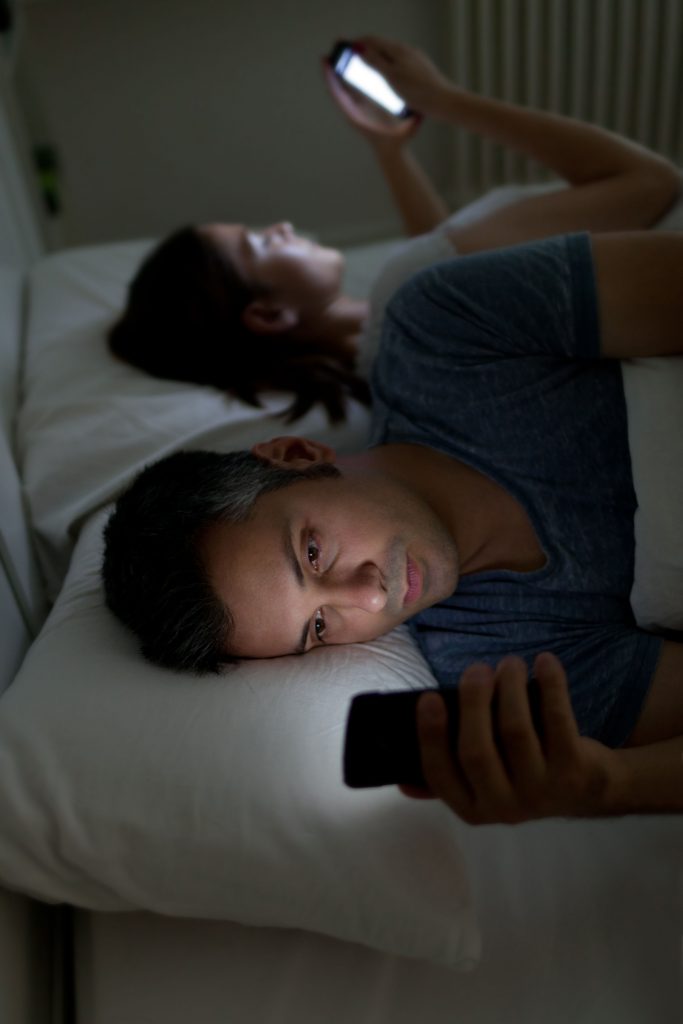 43375467 - young couple with smartphones in their bed