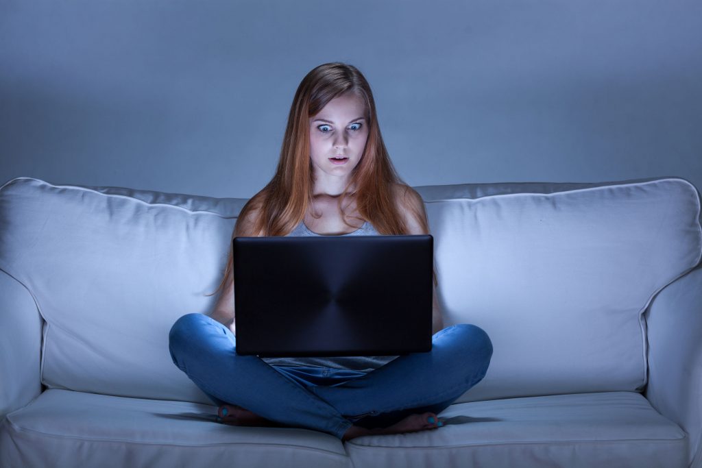 31480030 - image of shocked girl using facebook at night