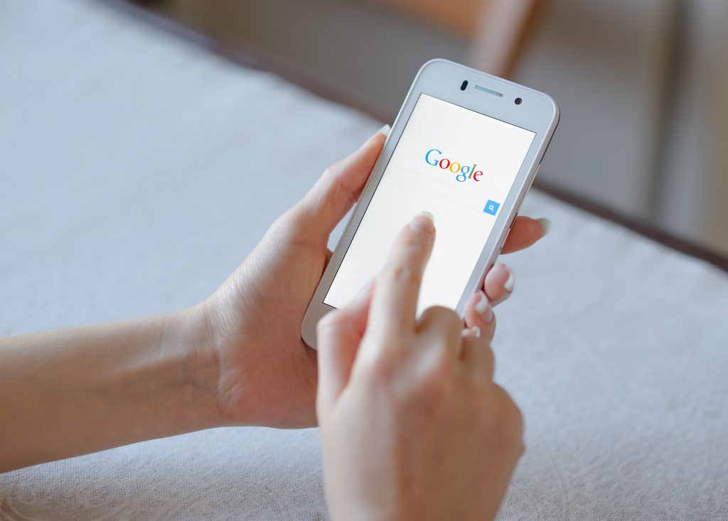 ZAPORIZHZHYA, UKRAINE - NOVEMBER 21, 2014: Young Woman Using Google Web Search on her Smart Phone.