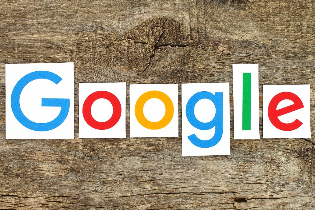 Kiev, Ukraine - January 12, 2016:New Google logotype printed on paper, cut and placed on old wood.Google is USA multinational corporation specializing in Internet-related services