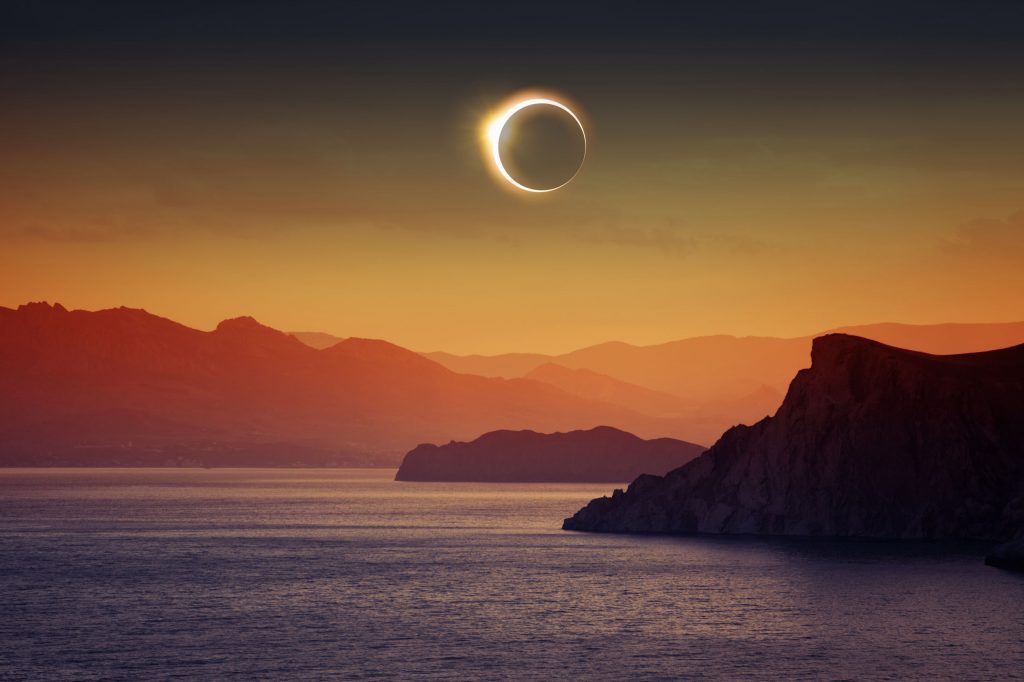 37434686 - scientific background, astronomical phenomenon - full sun eclipse, total solar eclipse, mountains and sea
