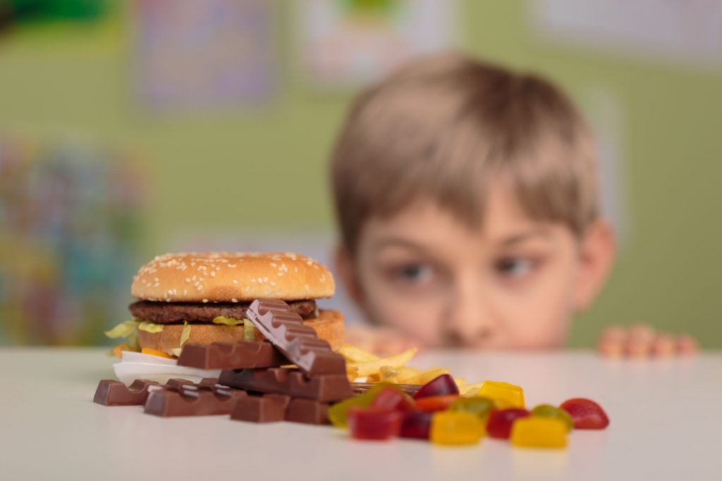 41795270 - greedy little boy looking at unhealthy tasty snacks