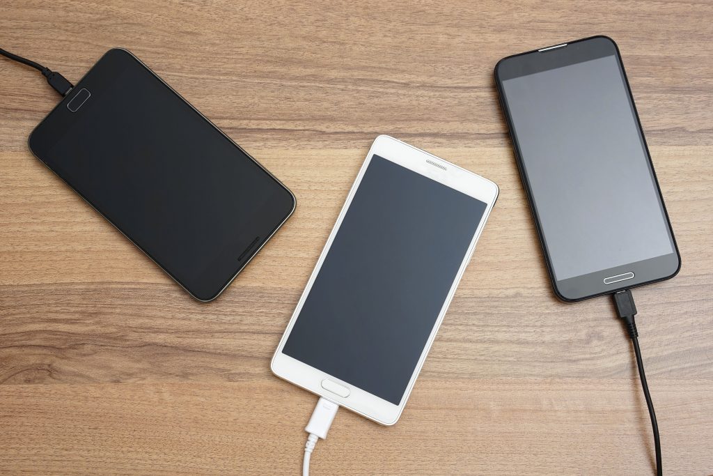 43132476 - mobile smart phones  charging on wooden desk
