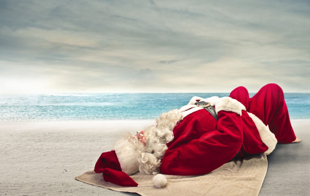22776300 - santa klaus relaxing on the beach