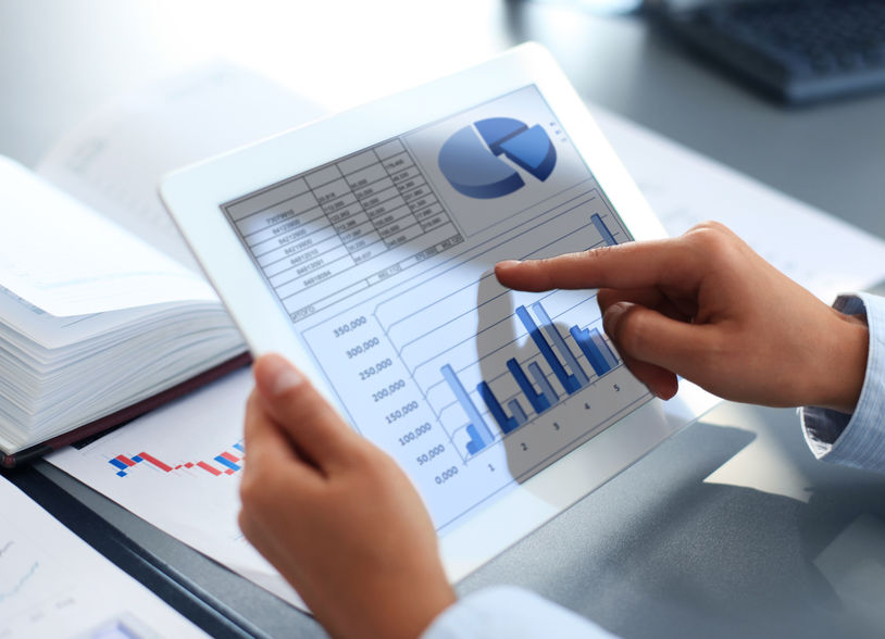 Business person analyzing financial statistics displayed on the tablet screen