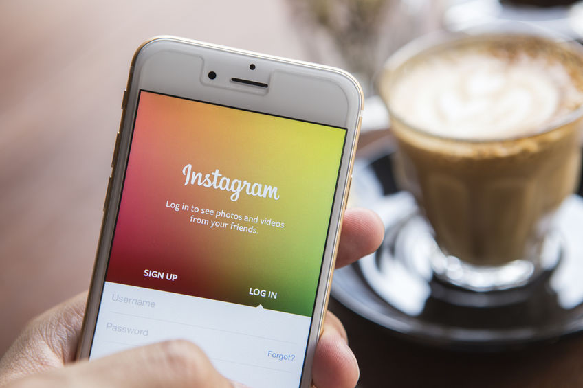 CHIANG MAI, THAILAND - APRIL 22, 2015: A man trying to log in Instagram application using Apple iPhone 6. Instagram is largest and most popular photograph social networking site in the world.